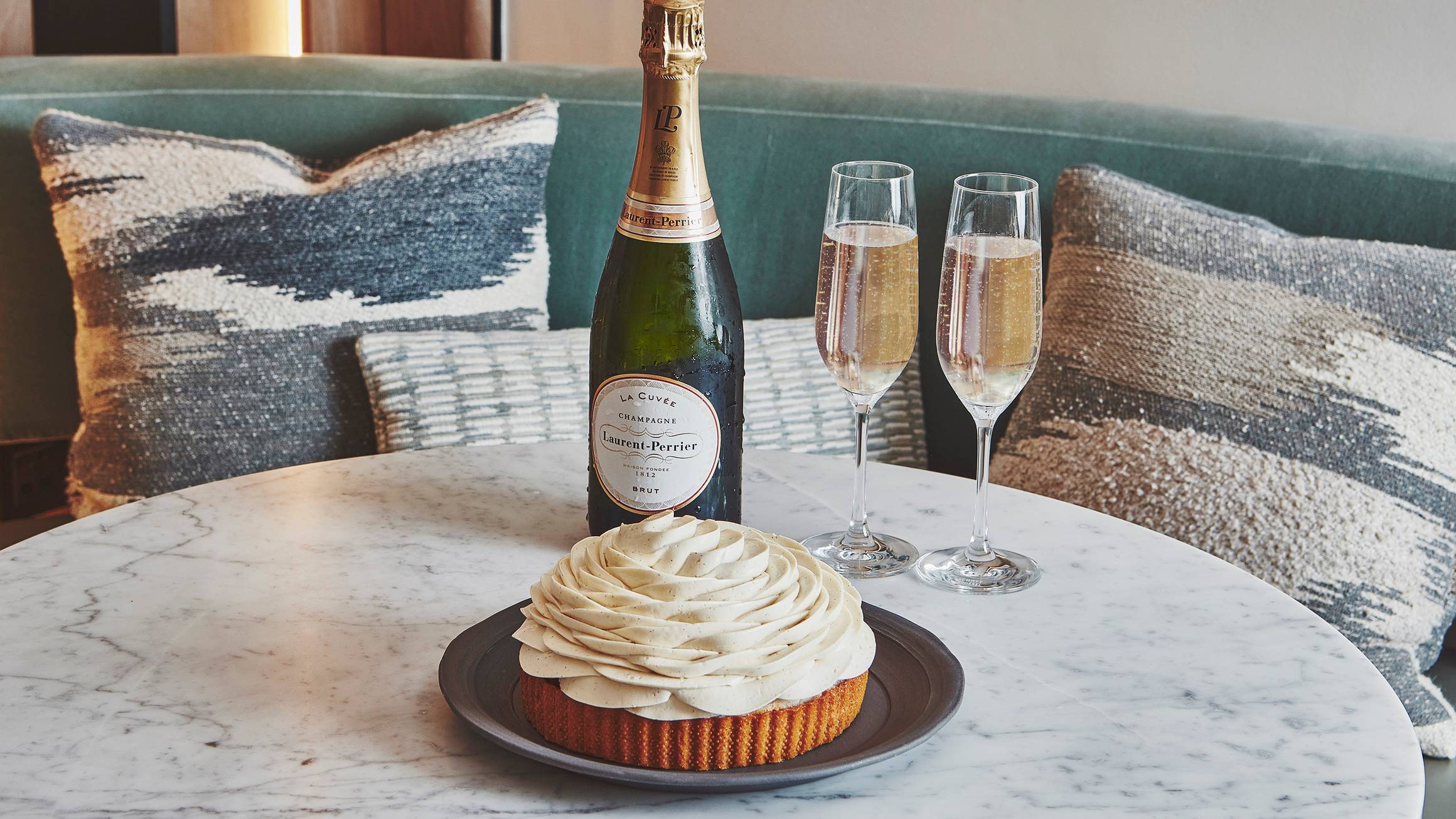 Cedric Grolet Cakes and a bottle of champagne sitting on a marble table