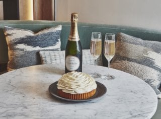 Cedric Grolet Cakes and a bottle of champagne sitting on a marble table